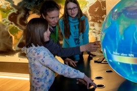 Leiterin Brigitte Eckle zeigt Kindern etwas auf dem Vision Globe © Nationalpark Hohe Tauern, Armin Kleinlercher Leiterin Brigitte Eckle zeigt Kindern etwas auf dem Vision Globe