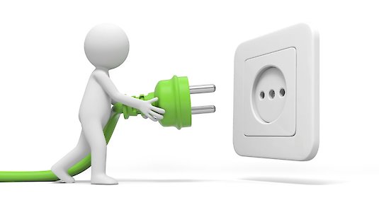 Grüner Stromstecker wird in graue Steckdose gesteckt Grüner Stromstecker wird in graue Steckdose gesteckt