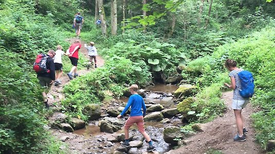 Wanderer beim Überqueren eines Baches Wanderer beim Überqueren eines Baches