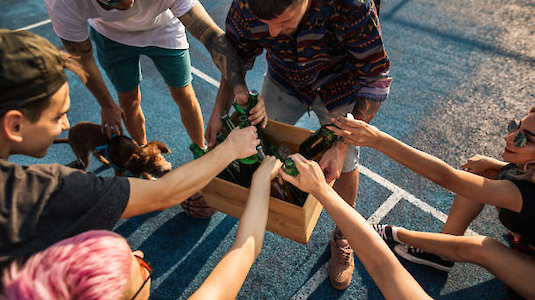 Menschen nehmen sich Getränke in Mehrwegflaschen. Menschen nehmen sich Getränke in Mehrwegflaschen.