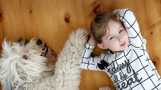 Kind und Hind liegen am Holzdielenboden